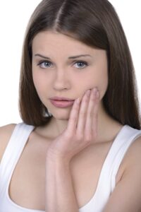 Toothache-Pain-in-Girl-holding-hand-to-cheek