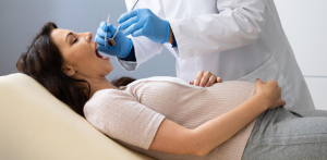 A pregnant woman at a dental check-up, highlighting safe practices during pregnancy.