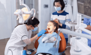 A young girl in a dental chair underscores the importance of preventive dentistry for kids.